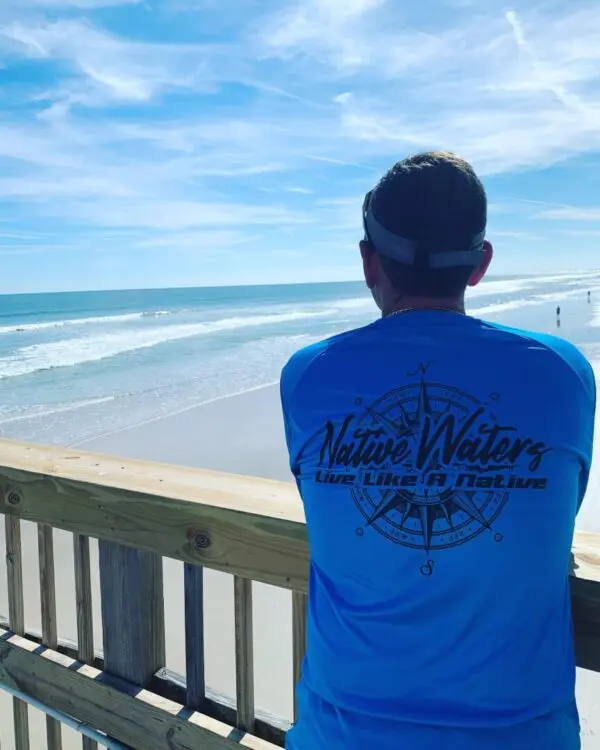 A man standing on the side of a beach.