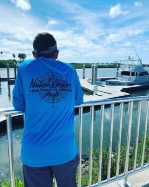 A man standing on the side of a pier.